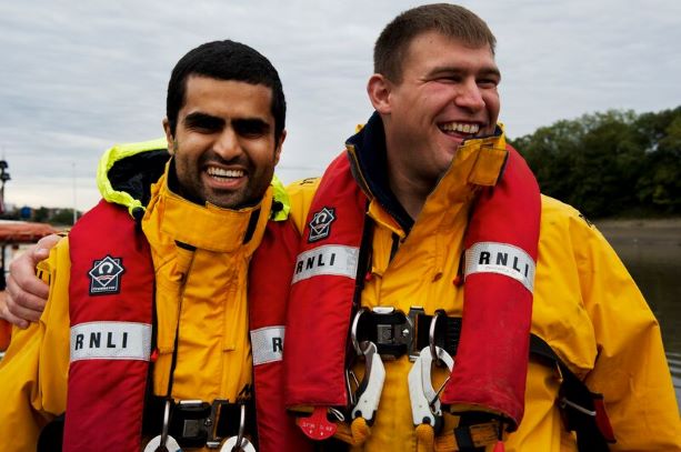 RNLI crew members with arms round each other wearing life jackets